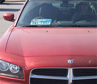 Plate in window of Dodge sedan